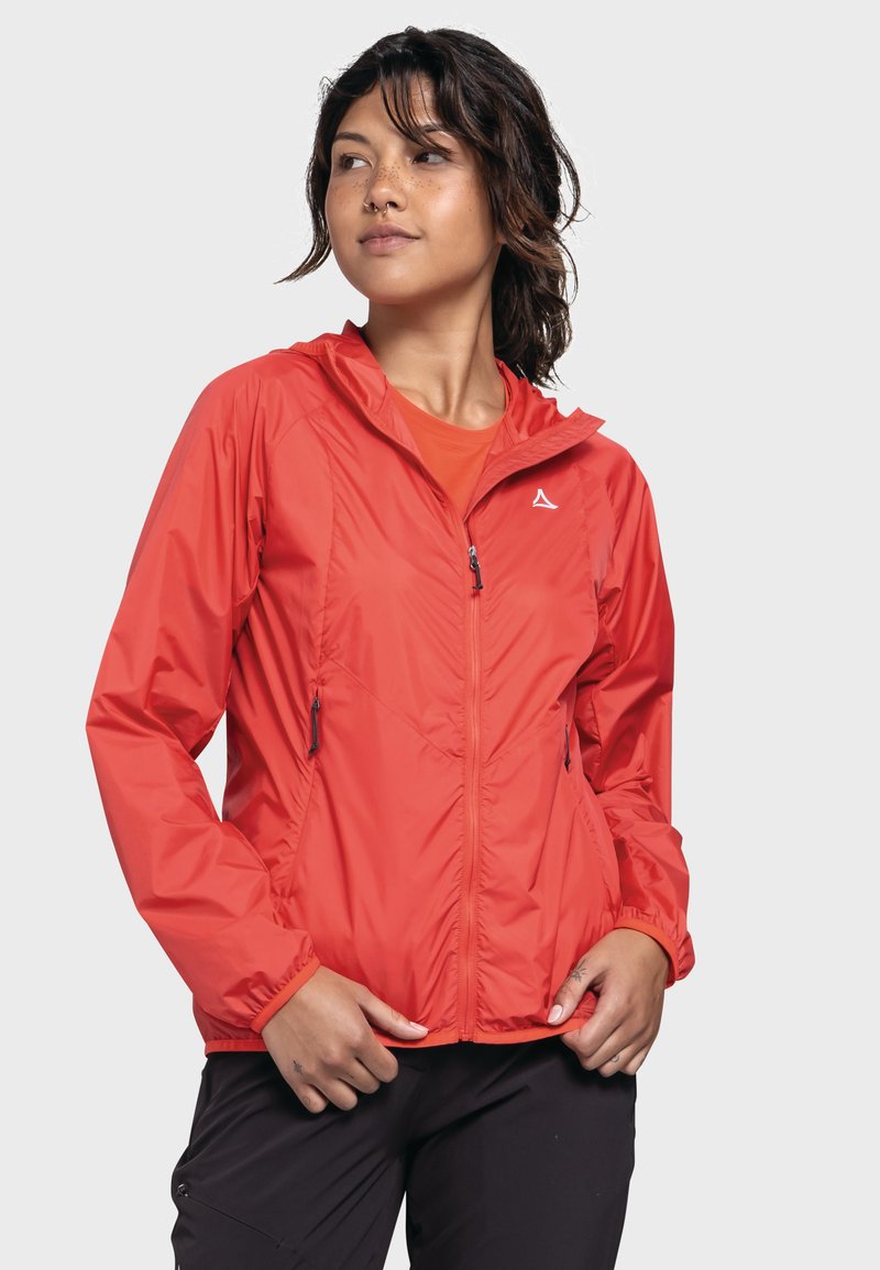 Rote leichte Jacke mit Kapuze, Reißverschluss vorne, elastischen Bündchen und zwei Seitentaschen. Verfügt über eine strukturierte Oberfläche und ein reflektierendes Logo.