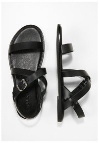 Svarta lädersandaler med flera remmar och justerbara spännen. Platt sula med texturerad fotbädd och en ren, minimal design.