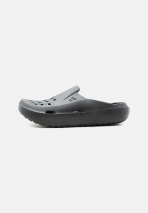 Μαύρο τσόκαρο τύπου slip-on με οπές αερισμού πάνω και στα πλάγια, με παχύ μαλακό πάτο και υφή στο πέλμα.