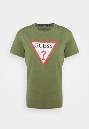 T-shirt à manches courtes vert olive avec un logo triangulaire blanc bordé de rouge, affichant "GUESS U.S.A." et un point d'interrogation rouge au centre.