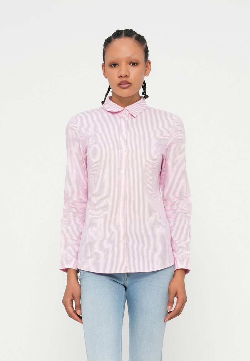Camisa de botão riscada em rosa e branco, com colarinho, mangas longas e um design justo. A textura do tecido parece suave e leve.