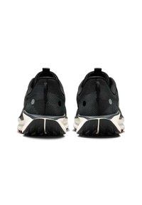 Zapatillas de correr negras con parte superior de malla texturizada, cuello acolchado y suela de goma con patrones de tracción elevados. Asa en el talón.