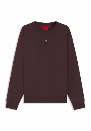 Bordeauxrotes Sweatshirt mit Rundhalsausschnitt, langen Ärmeln und gerippten Bündchen. Verfügt über einen kleinen schwarzen Logo-Patch auf der Brust und ein rotes Innenetikett.