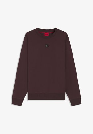 Felpa color amaranto con scollo rotondo, maniche lunghe e polsini a coste. Presenta una piccola toppa con logo nero sul petto e un'etichetta interna rossa.