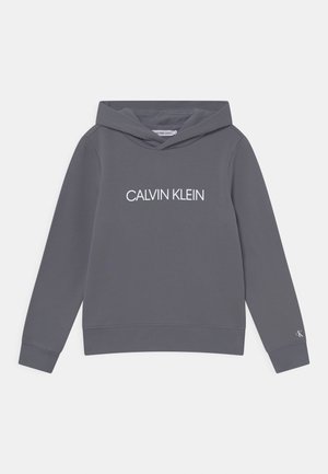 Grijze hoodie met lange mouwen, met "CALVIN KLEIN" in witte letters gedrukt op de borst en een kleine "CK"-logo op de linker manchett.