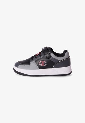 Baskets noires et grises avec semelle blanche, sangle Velcro, lacets noirs et logo Champion sur le côté et à l'arrière.