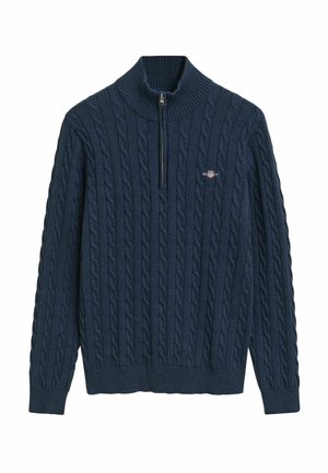 Pull-over en bleu marine avec un col côtelé haut, une fermeture éclair quart et une texture en tricot torsadé. Petit logo sur la poitrine.