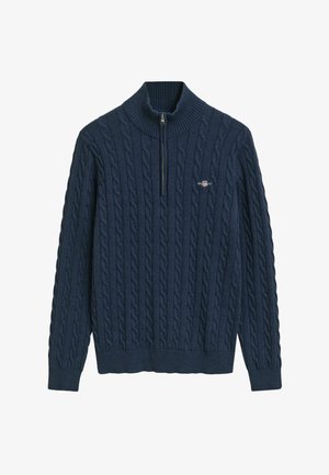 Marineblauwe pullovertrui met een hoge ribbelkraag, kwartrits en kabelbrei-textuur. Klein logo op de borst.