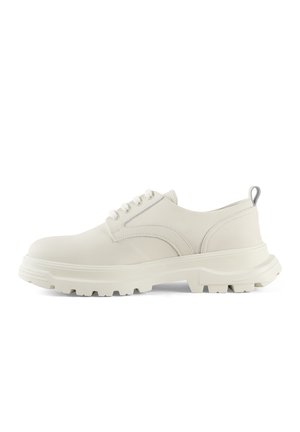 Scarpe in pelle bianca con lacci, suola in gomma spessa e testurizzata, punta arrotondata e dettagli di cucitura discreti. Include un tab di presa posteriore.
