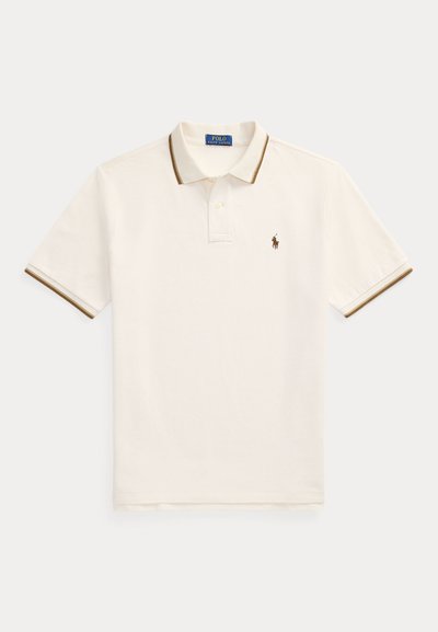 Bílá polo košile s hnědým žebrovaným límcem a manžetami na rukávech. Má tříknopovou légu a malé vyšívané logo na prsou.