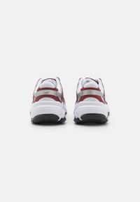 Sneakers bianchi con accenti in suede rosso e dettagli in metallo argentato. Caratterizzati da una suola imbottita e pannelli in rete testurizzati per la traspirabilità.