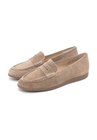 Een paar beige suède instap loafers met lage hakken en decoratieve stiksels op een witte achtergrond.