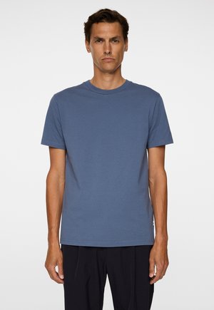 Kortærmet crew neck t-shirt i dæmpet blå bomuld, med lige søm og subtilt logo-detalje nederst til venstre.
