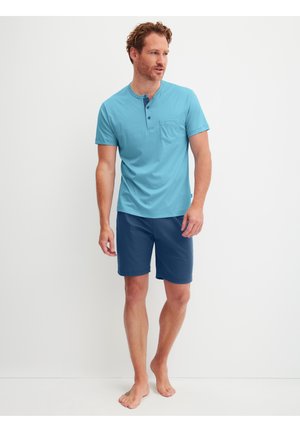 Chemise henley à manches courtes bleu clair avec une poche poitrine, associée à un short bleu foncé. Tissu doux, coupe décontractée et design simple.