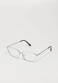 Lunettes en métal avec une fine monture argentée, des verres angulaires, en verre clair, et des accents en caoutchouc noir sur les embouts des branches. Design léger et minimaliste.