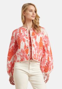 Quilted crop jack in levendige roze en oranje tinten met opbollende mouwen, knoopsluiting en contrasterende afwerking. Gladde textuur met een gedurfd patroon.