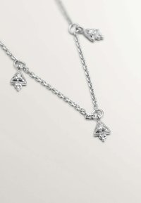 Collar de cadena de plata que presenta tres colgantes triangulares con un diseño intrincado y pequeños adornos. Textura suave con un acabado pulido.