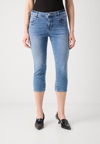 Vaqueros cortos de color azul claro con un diseño ajustado, que presentan un estilo de cinco bolsillos, pasadores para cinturón y una textura ligeramente desgastada.