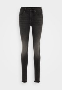 Jeans ajustados en denim negro desgastado, con una cintura de altura media, diseño de cinco bolsillos y dobladillo deshilachado en los tobillos. Textura suave y ajuste elástico.