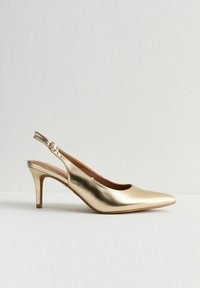 Zapato de tacón alto de slingback metálico dorado con punta afilada y correa con hebilla, exhibido sobre un fondo blanco liso.