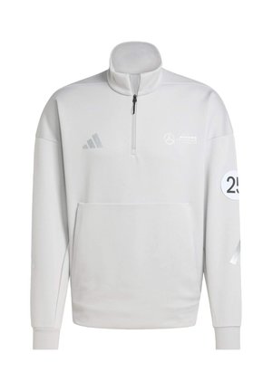 Vit sweatshirt med halvdragkedja i kragen, framficka och broderade logotyper. Har grå detaljer och ett tre-stripes mönster på ärmarna.