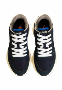 Sneaker blu navy con lacci bianchi, tomaia in tessuto, colletto imbottito e suola in gomma beige. Presenta un marchio sulla linguetta.