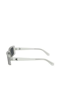 Ochelari de soare din acril transparent cu un cadru rectangular, lentile întunecate și brațe conice, având un logo negru pe lateral.