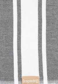 Streifenstoff in Schwarz und Weiß mit einem strukturierten Muster. Unten befindet sich ein Etikett mit dem Markennamen "[espadrij]".