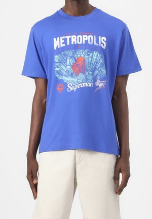 Blauwe katoenen t-shirt met een grafische print van de skyline van Metropolis met Superman, in rood en wit, crew neck, losse pasvorm.