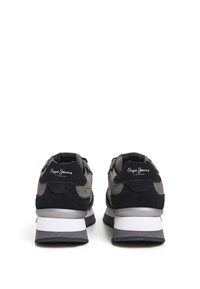 Sneaker neri e grigi realizzati in materiali scamosciati e in rete. Inclusa una suola intermedia bianca e dettagli di marca sul retro. Punta arrotondata e colletto imbottito.