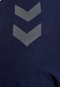 Granatowa koszulka z teksturowanej tkaniny, z dwoma szarymi, wznoszącymi się akcentami w kształcie chevron na plecach.