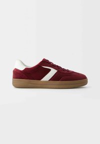 Baskets basses bordeaux avec accent blanc, semelle en gomme et fermeture à lacets, vues de profil sur fond uni.