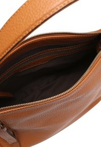 Braune, strukturierte Lederhandtasche mit einem Reißverschluss, innen mit dunkel gefüttert und zusätzlich einem Reißverschlussfach.