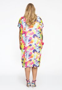 Robe maxi colorée à coupe oversize, ornée de formes abstraites en rose, jaune, violet et bleu sur un fond blanc. Manches courtes.