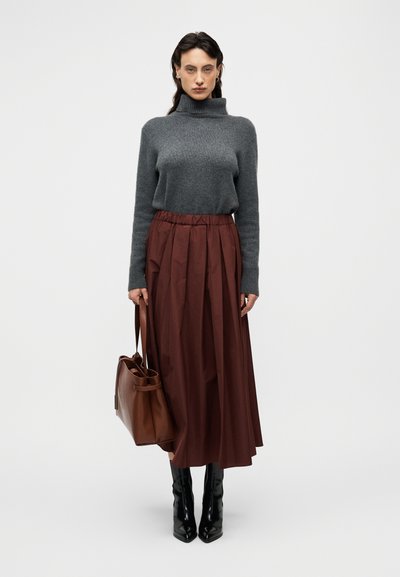 Γκρι πλεκτός πουλόβερ με λαιμόκοψη, φούστα με πιέτες σε μπορντό χρώμα και ψηλή μέση, μαύρες μπότες μέχρι το γόνατο και καφέ δερμάτινη τσάντα χειρός. Λείες υφές και προσαρμοσμένη εφαρμογή.