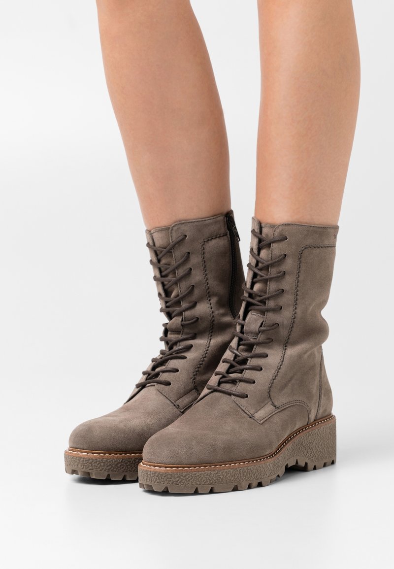 Bottes de combat en daim gris avec laçage sur le devant, fermeture éclair latérale et semelle plateforme texturée dotée d'une bande de roulement robuste. Finition lisse et détails de coutures.