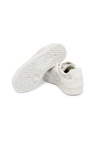 White sneakers with a smooth leather upper, patterned textile accents, round rubber outsole with circular treads, and a cushioned collar.