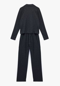 Conjunto de loungewear de dos piezas en gris que incluye una parte superior de manga larga con cuello y pantalones con cintura elástica, ambos fabricados en un suave tejido texturizado.