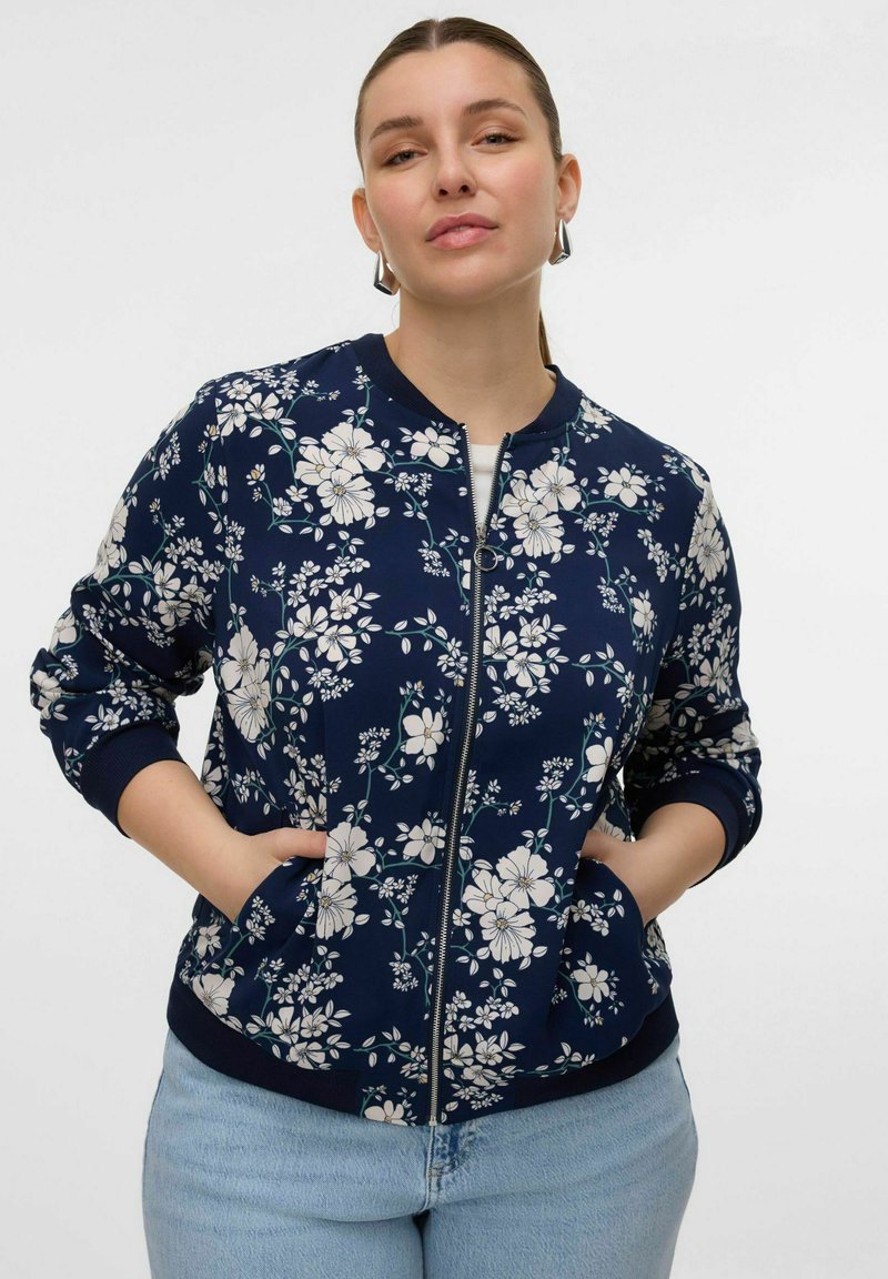 Navy floral bomber jacket with white flowers, ribbed cuffs, and hem, featuring a zip front and side pockets, in a soft fabric.