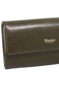 Green faux leather wallet with a flap closure, featuring visible stitching and a gold "Dune London" logo near the bottom.