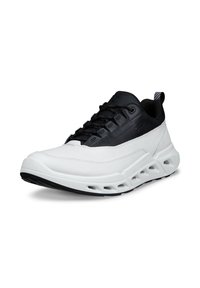 Chaussure de sport avec une semelle en caoutchouc blanc, une tige synthétique noire, des lacets à motifs et un embout texturé. Dotée d'une languette à l'arrière du talon.