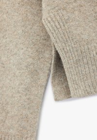 Lichtgrijs gebreid sweater met een zachte textuur, geribde manchetten en subtiele kleurvariaties door de stof.