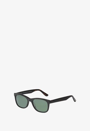 Musta ja kilpkonna mustriga päikeseprillid roheliste läätsedega, ristkülikukujuline ja laia sangaga. Valmistatud taaskasutatud materjalidest.