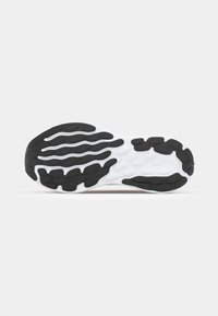 Semelle de sneaker noire et blanche avec un motif texturé, des rainures flexibles pour l'adhérence et un intercalaire blanc lisse.