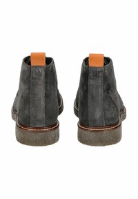 Botas de tobillo de ante gris con una tira de piel en tono marrón claro, suela marrón contrastante y acabado texturizado en la suela para mayor agarre.