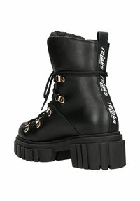 Zwarte leren enkellaars met nepbontvoering, gouden hardware en dikke rubberen zool. Voorzien van een vetersluiting aan de voorkant en een merklabel aan de achterkant.