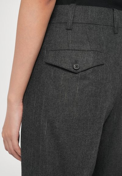 Tummanharmaat housut, jotka on valmistettu teksturoidusta kankaasta. Niissä on yksi takatasku mustalla napilla ja huomaamaton pinstripe-kuvio.