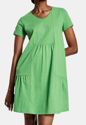Robe verte à manches courtes en coton doux avec un décolleté en V, dotée de poches latérales et d'une jupe froncée à plusieurs volants.