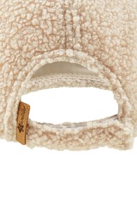 Beige Lammfellmütze mit einer strukturierten, flauschigen Oberfläche. Verfügt über ein Lederetikett und einen verstellbaren Riemen auf der Rückseite für eine individuelle Passform.