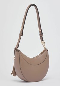 Sac d'épaule en cuir marron avec une forme incurvée, des détails de bordure noirs, une fermeture éclair dorée et un pompon décoratif sur le côté.